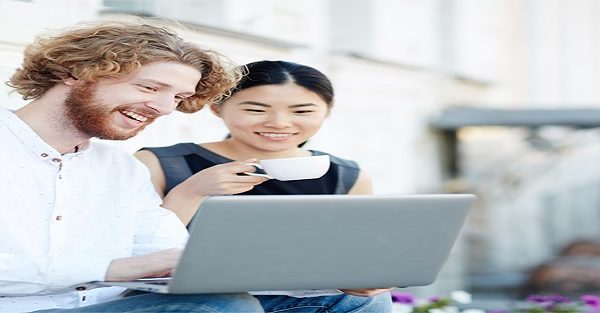 Asian girl and Caucasian guy with laptop watching curious video in the net in urban environment